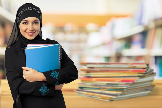 Joven musulmana con libro en blanco