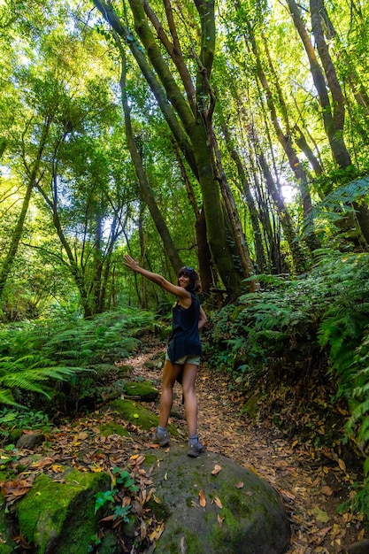 Una joven muy feliz caminando por el sendero junto a los helechos en el Cubo de la Galga