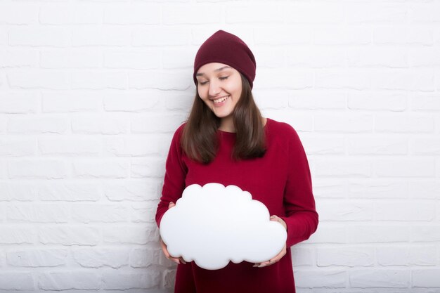 Una joven muy sonriente sostiene una nube en la mano