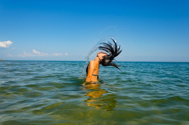 Una joven nada en el mar en un día de verano.