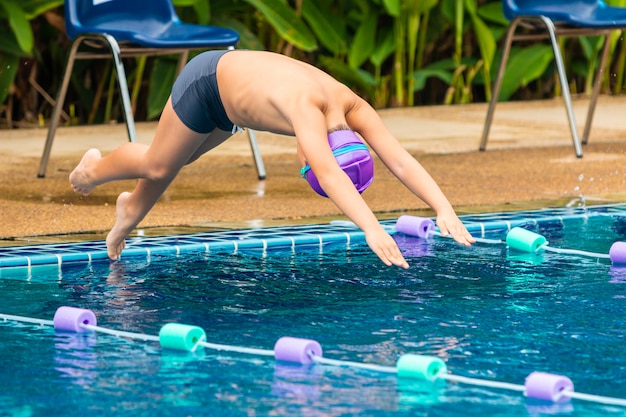 Foto joven nadador buceando a la piscina.