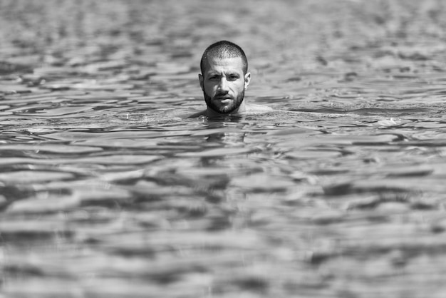 Joven nadando en el agua verde del lago