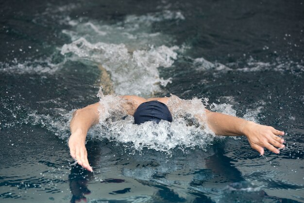 Joven nadando la mariposa en una piscina.