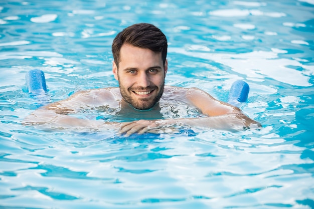 Joven nadando con tubo inflable en la piscina