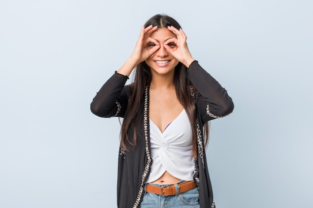 Joven natural y bastante árabe mostrando signo bien en los ojos