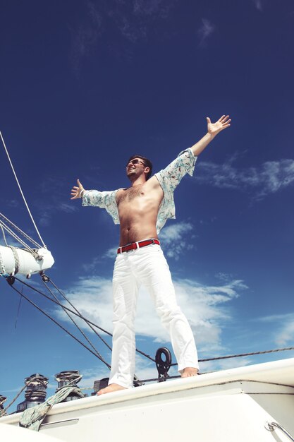 Joven navegando en su barco en mar abierto