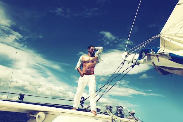 Foto joven navegando en su barco en mar abierto