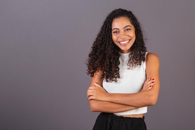 Foto joven negra brasileña con los brazos cruzados sonriendo