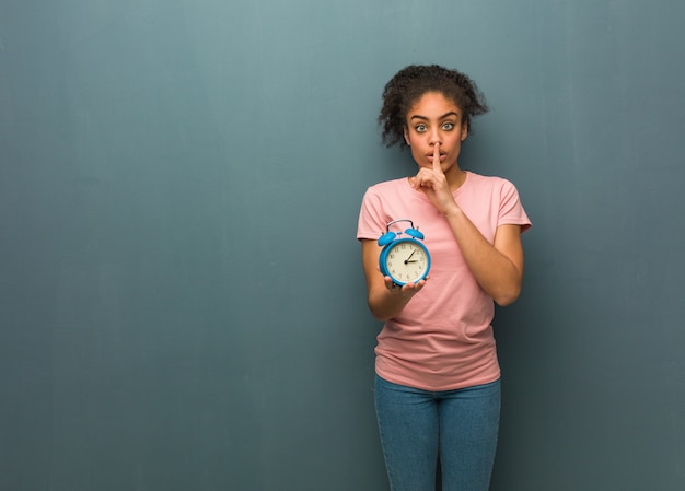 Joven negra guardando un secreto o pidiendo silencio