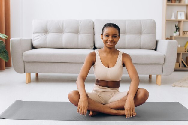 Joven negra meditando en casa, concepto de yoga en línea, espacio libre