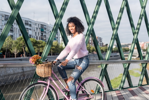 Joven negra montando una bicicleta vintage