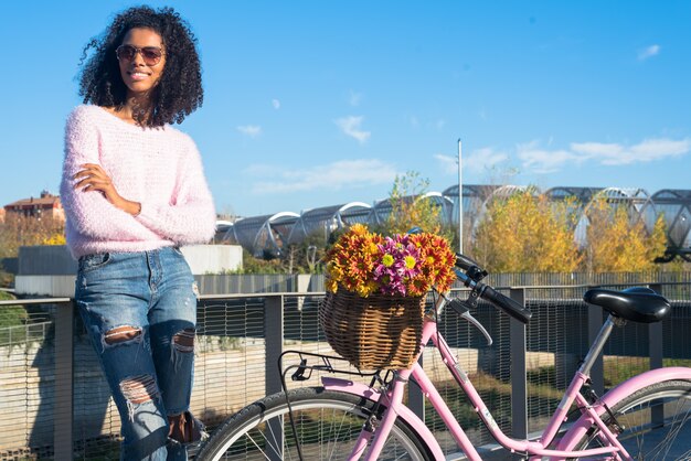 Joven negra montando una bicicleta vintage