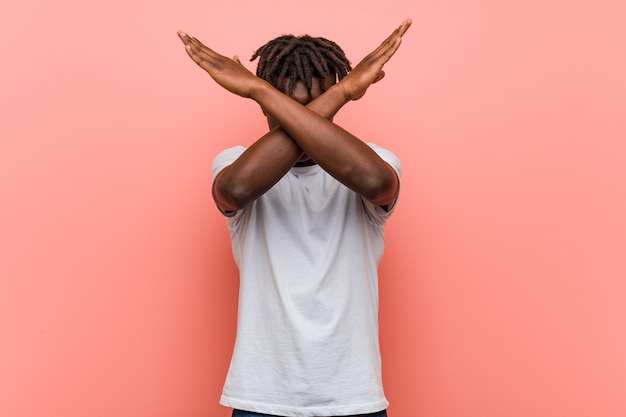 Joven negro africano manteniendo dos brazos cruzados