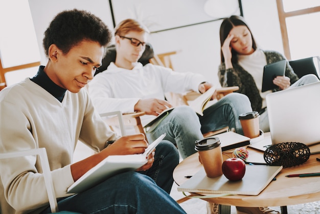 El joven negro está escribiendo en Notepade