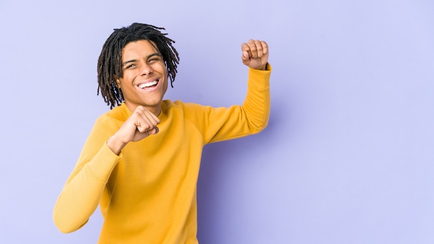 Joven negro con peinado rasta bailando y divirtiéndose.