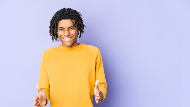 Joven negro con peinado rasta sosteniendo algo con ambas manos, presentación del producto.