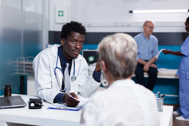 Joven negro con profesión médica consultoría anciana