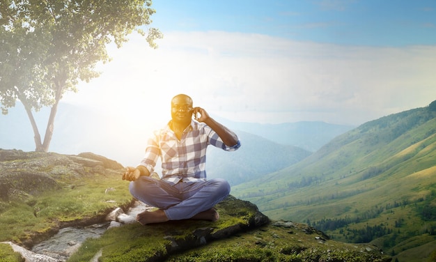 Joven negro sentado y meditando. Técnica mixta