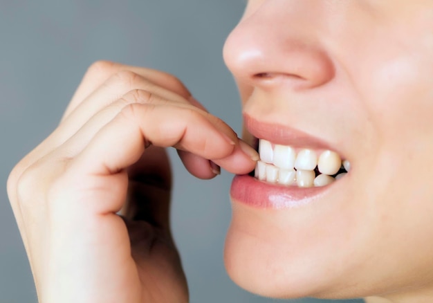 Joven nerviosa mordiéndose las uñas