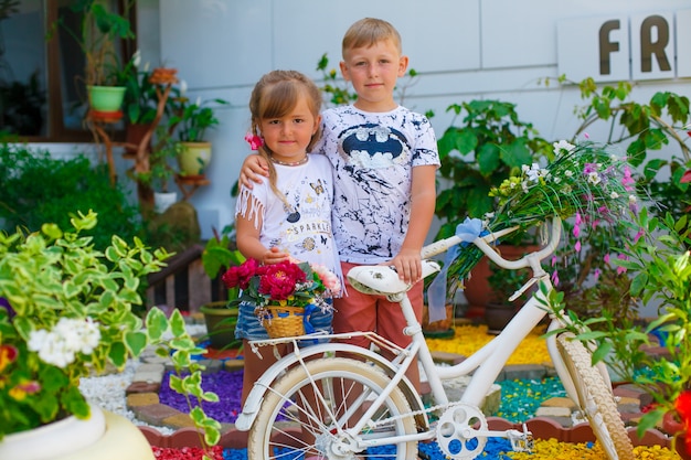 Un joven niño feliz y su hermanita linda caminando en un cálido día de verano.