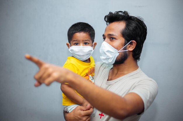 Un joven y un niño pequeño asiático que usan una máscara facial para la seguridad del coronavirus Pandemia de coronavirus