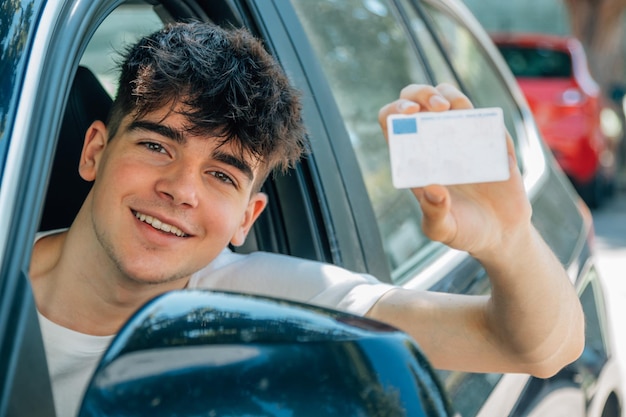 Foto joven nobel en el coche con licencia de conducir