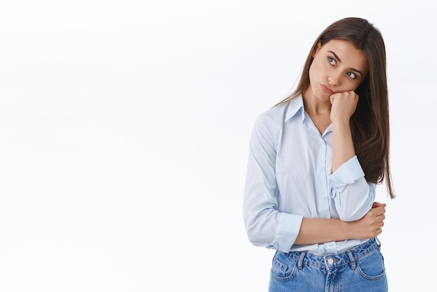 Foto una joven novia aburrida y triste esperó todo el día a que su novio estuviera presente apoyado en la palma de la mano con una mirada sombría y disgustada ofendida y enfurruñada por el insulto de pie trastornado de fondo blanco