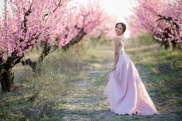 Joven novia hermosa en el jardín de flores.