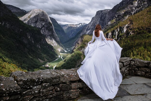 Joven novia hermosa en un vestido de novia en la naturaleza