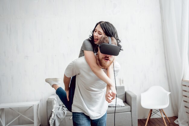 El joven con novia jugando con gafas de realidad virtual