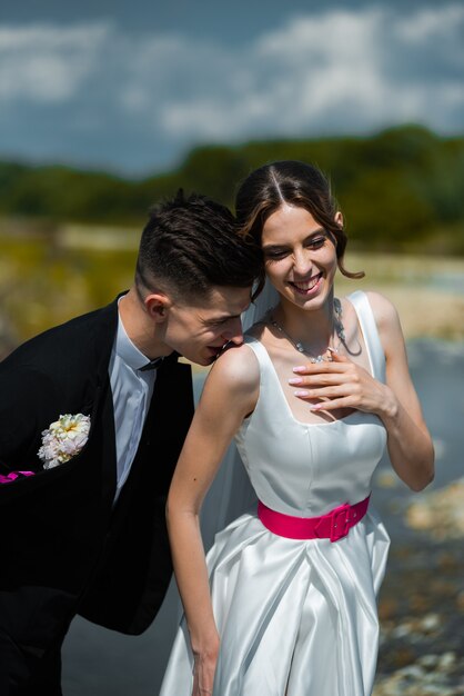 Joven novia y el novio caminando al aire libre día de la boda