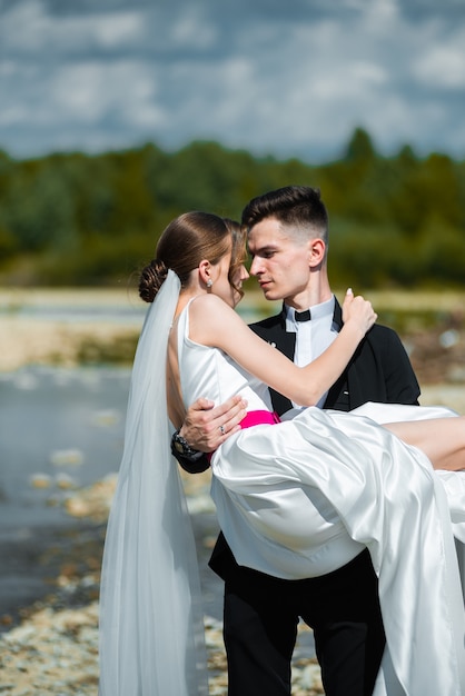 joven novia y el novio cerca del río