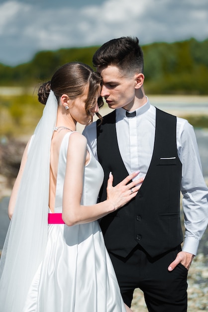 joven novia y el novio cerca del río