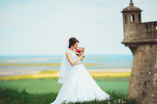 Joven novia en vestido de novia, en el parque