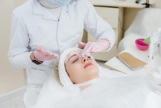 Una joven en una oficina de cosmetología se somete a procedimientos de rejuvenecimiento de la piel facial. Cosmetología.