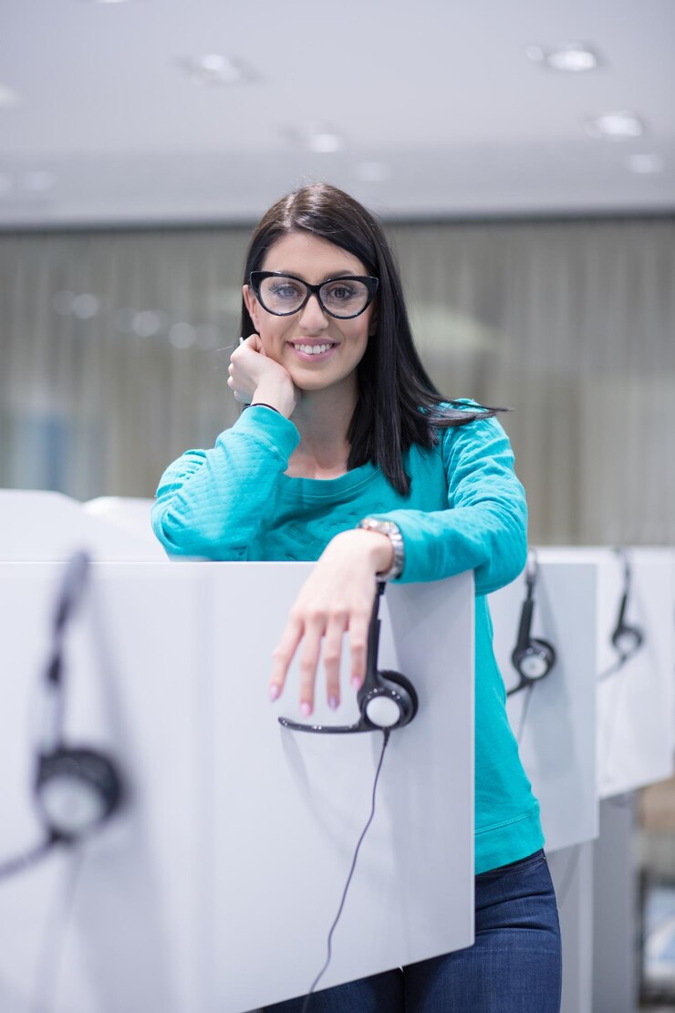 Foto joven operadora de centro de llamadas femenina sonriente haciendo su trabajo con un auricular