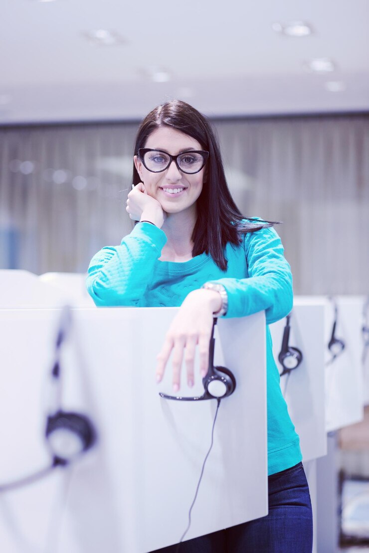Foto joven operadora de centro de llamadas femenina sonriente haciendo su trabajo con un auricular