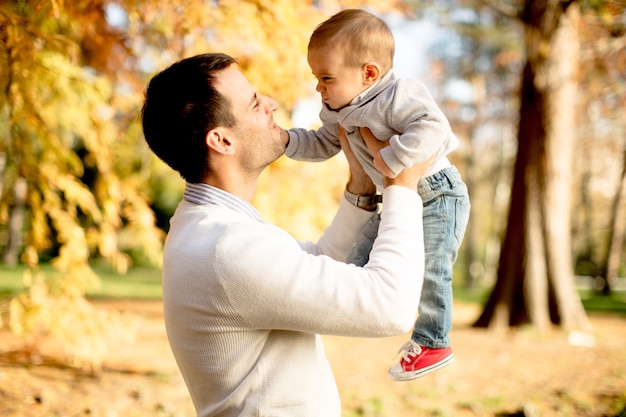 Joven padre y bebé en el parque de otoño