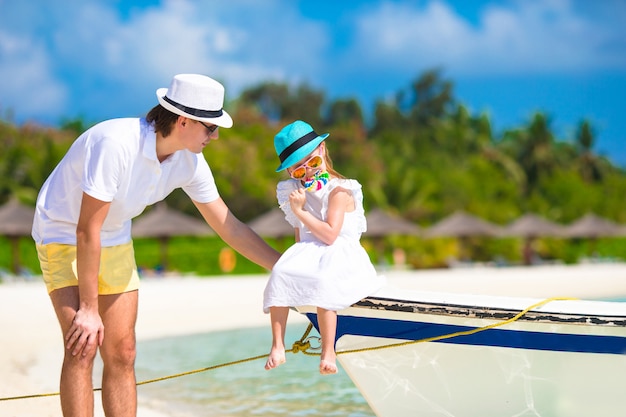 Joven padre e hija pequeña en playa tropical