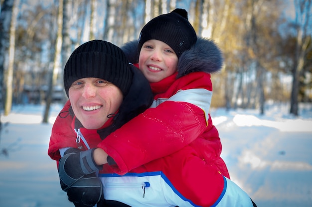 Joven padre e hijo en paisaje de invierno