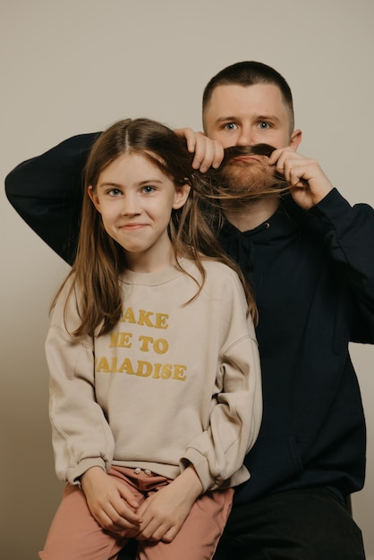 Un joven padre feliz con barba jugando con su linda hija.