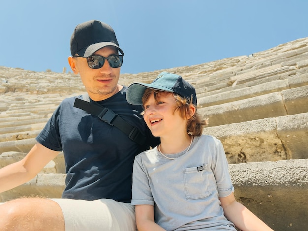 Joven padre papá y su escolar niño hijo turistas visitando el antiguo anfiteatro antiguo coliseo