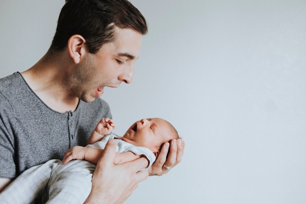 Joven padre sosteniendo a su bebé