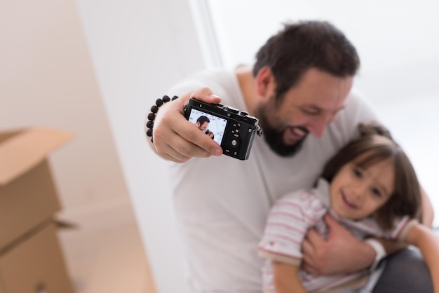 el joven padre y su hijo se fotografiaron con cajas de cartón a su alrededor mientras se mudaban a su nuevo hogar