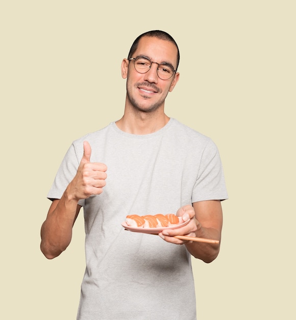 Joven con palillos para comer sushi