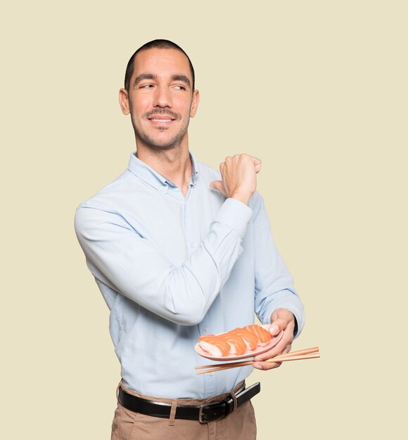 Joven con palillos para comer sushi