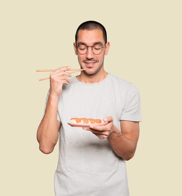 Joven con palillos para comer sushi