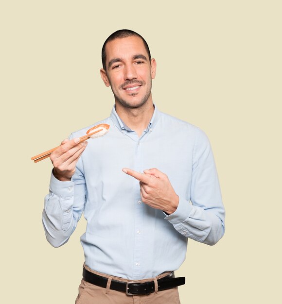 Joven con palillos para comer sushi