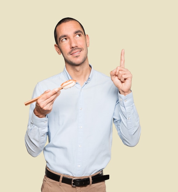 Foto joven con palillos para comer sushi