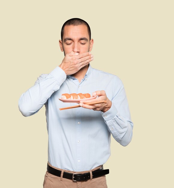 Joven con palillos para comer sushi